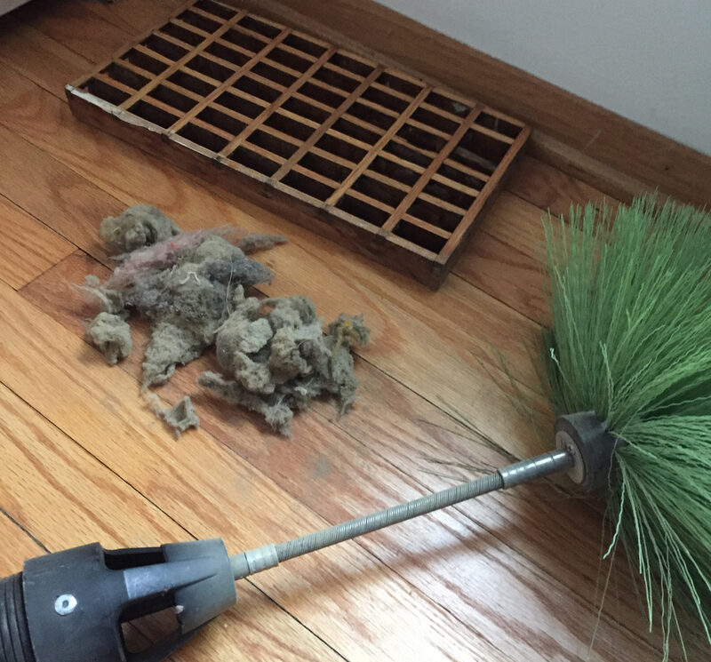 Rotobrush tool next to dust removed from air ducts